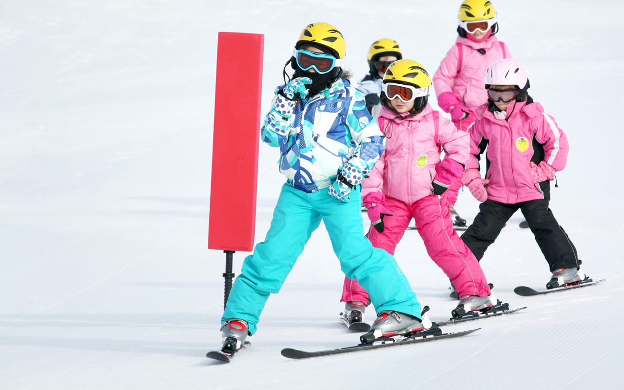 Drei Kinder fahren eine Piste hinunter